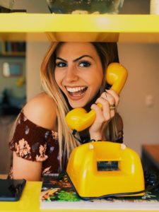 girl smiling holding yellow phone