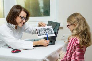 female orthodontist showing an x-ray to a child