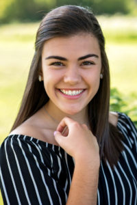 girl in black & white striped shirt smiling