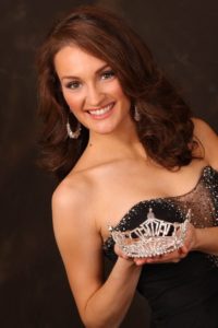 girl smiling holding a tiara